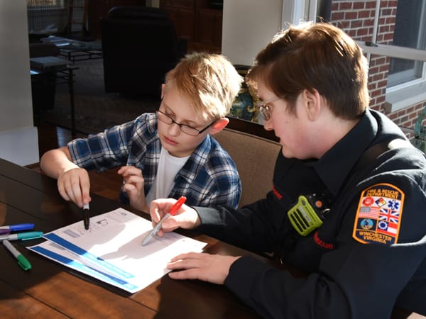 firefighter showing a boy how to make a home fire escape plan