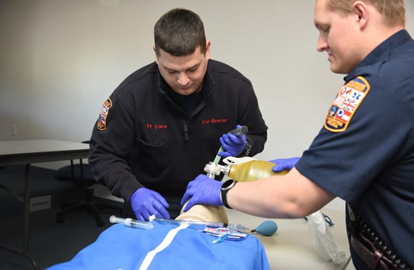 EMTs intubating training mannequin