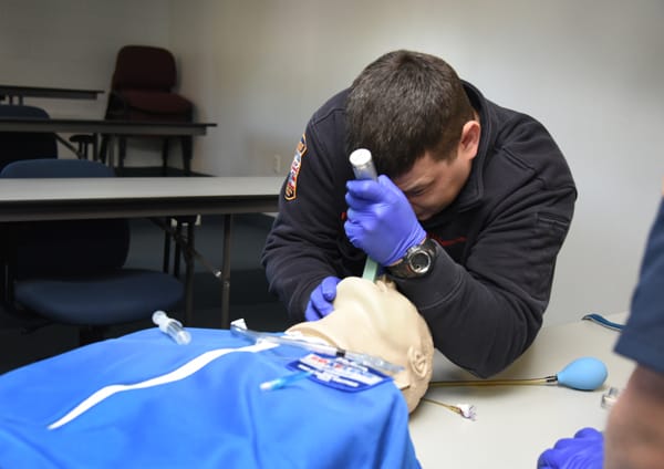 EMTs intubating training mannequin